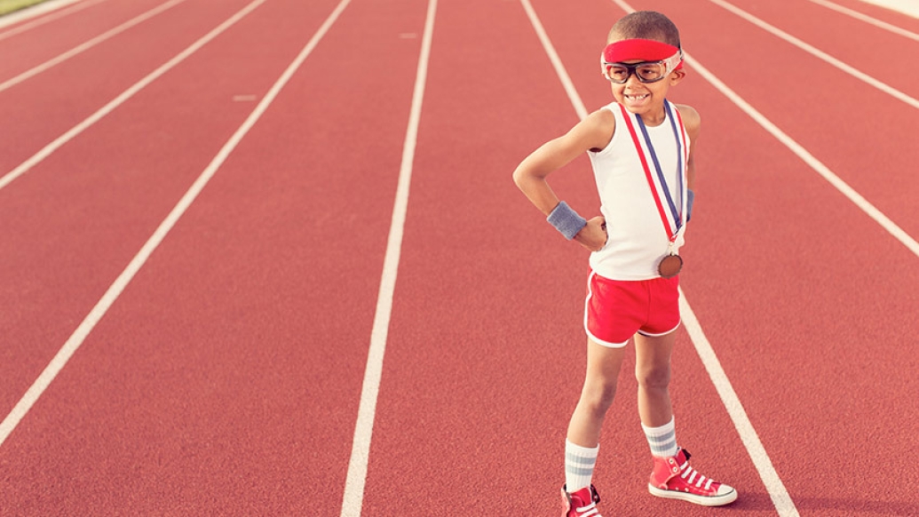 athlete boy in white shirt and red shorts on red track goggles medal 