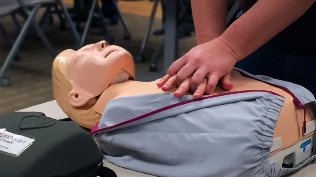 photo of hands on dummy mannequin chest indicating CPR