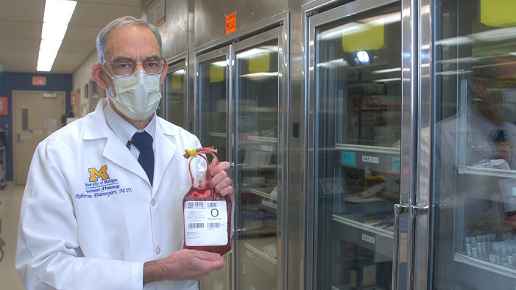doctor in mask holding blood bag