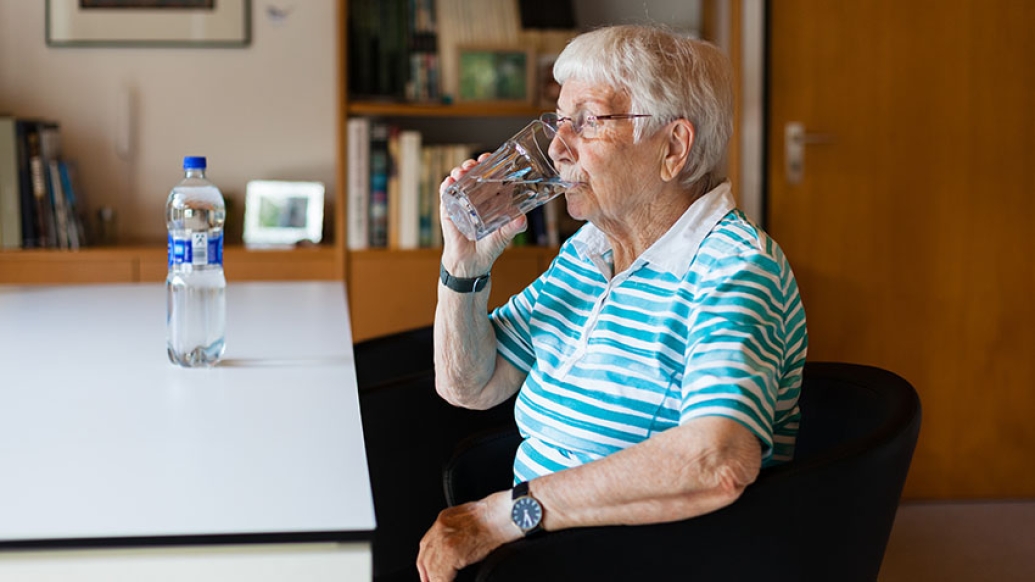 Patient at desk drinking a fluid