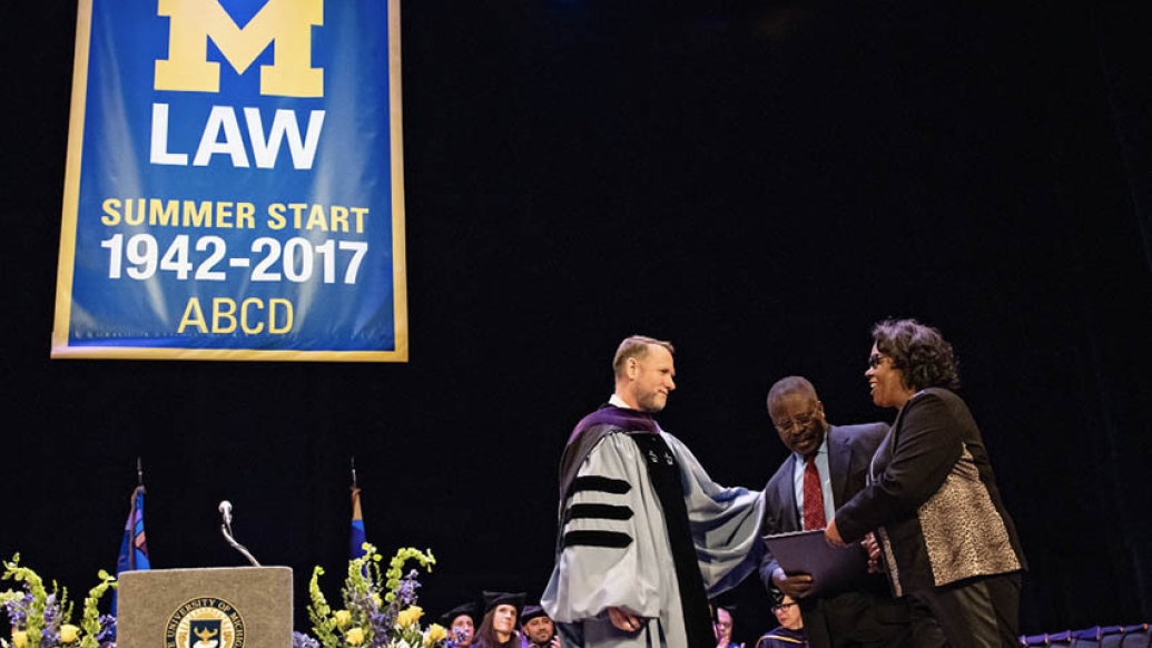 Parents being handed law degree at U-M law school ceremony