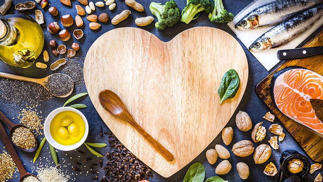 Heart shaped cutting board with wooden spoon and food around