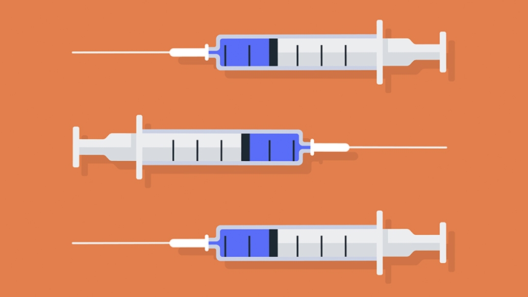 Three syringes with vaccine on orange background
